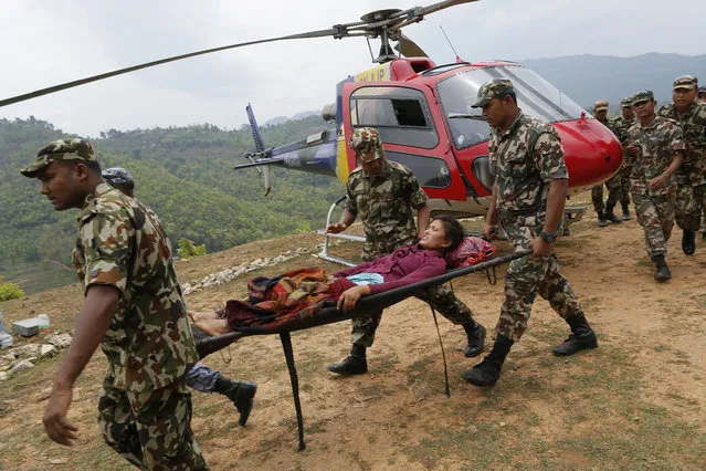 Sita Karka, suffering two broken legs from Saturday's massive earthquake, arrives by helicopter from the heavily-damaged Ranachour village at a landing zone in the town of Gorkha, Nepal, Tuesday, April 28, 2015. (Photo by Wally Santana/AP Photo)