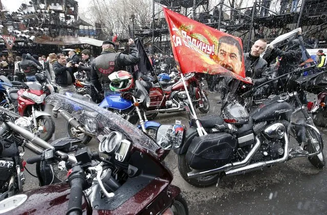 A man adjusts a flag before a farewell ceremony to see off participants of a bike ride, commemorating the 70th anniversary of the victory over Nazi Germany in World War Two, at a bike centre in Moscow, April 25, 2015. Poland will not allow members of a Russian motorcycle club linked to President Vladimir Putin to cross its border and enter the European Union's territory, the Polish Foreign Ministry said on Friday, in a decision Moscow said was politically motivated. (Photo by Sergei Karpukhin/Reuters)