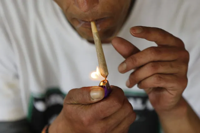 A visitor smokes marijuana at “Hippie Hill”, a retreat in the mountains surrounding Kathmandu, Nepal, Thursday, September 30, 2021. Widely available marijuana once drew thousands of hippies to Nepal, where its use was not only accepted but embedded in both the culture and religion.But the country followed other nations in outlawing marijuana in the late 1970s and chased away the hippies who came on buses from Europe and United States. Half a century later, campaigners are seeking to again legalize the farming, use and export of marijuana as more countries allow its medicinal and recreational use. (Photo by Niranjan Shrestha/AP Photo)