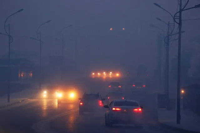 Cars drive through the thick haze on a cold polluted morning in Ulaanbaatar, Mongolia January 19, 2017. (Photo by B. Rentsendorj/Reuters)
