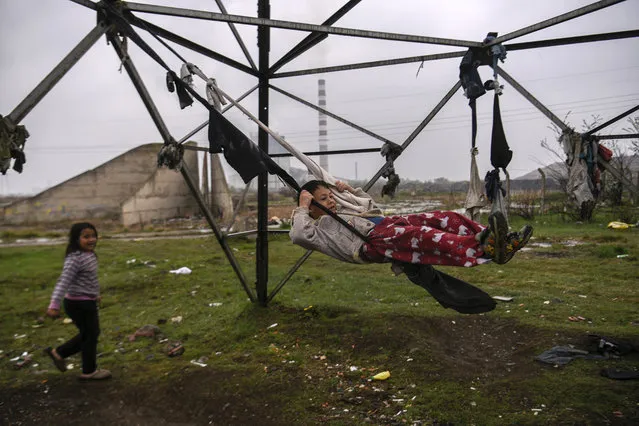 A Roma child swings on tied clothes near his shelter at a Roma Camp in the village of Plemetina, near Pristina on April 8, 2019, during the International Roma Day marked around Europe to celebrate Romani culture and raise awareness of the situation of Roma. (Photo by Armend Nimani/AFP Photo)