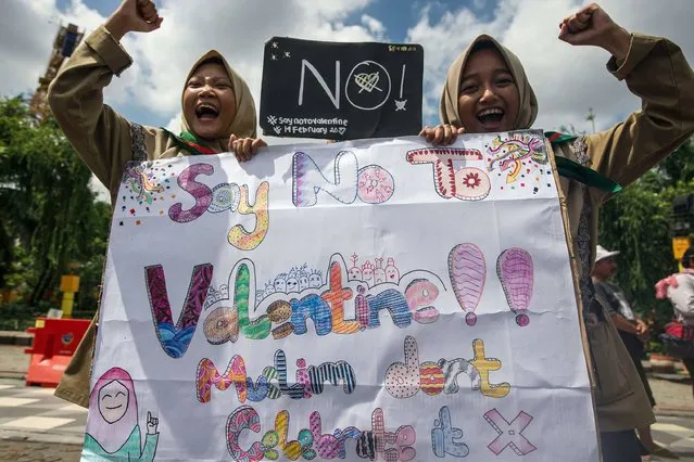 Girls from a local boarding school shout during an anti-Valentine's Day rally in Surabaya, East Java province on February 13, 2017. Conservative Indonesian Islamic groups have denounced Valentine's Day, saying it is un-Islamic, promoting promiscuity, casual sеx and consumption of alcohol while other groups described the day as foreign cultural influence. About 90 percent of Indonesia's 255 million inhabitants are Muslim but most practise a moderate form of Islam and have lived largely harmoniously alongside Christian, Buddhist and Hindu minorities. (Photo by Juni Kriswanto/AFP Photo)