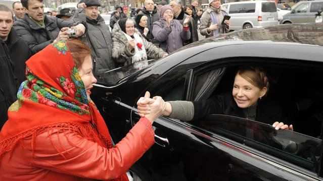 Ukrainian opposition leader Yulia Tymoshenko shakes hands with a woman as she arrives to visit the tent camp of her supporters in the center of Kiev on February 28, 2014. Judicial authorities in Geneva said Friday they have launched a criminal investigation into alleged money laundering by ousted Ukrainian leader Viktor Yanukovych and his son. (Photo by Yuriy Dyachyshyn/AFP Photo)