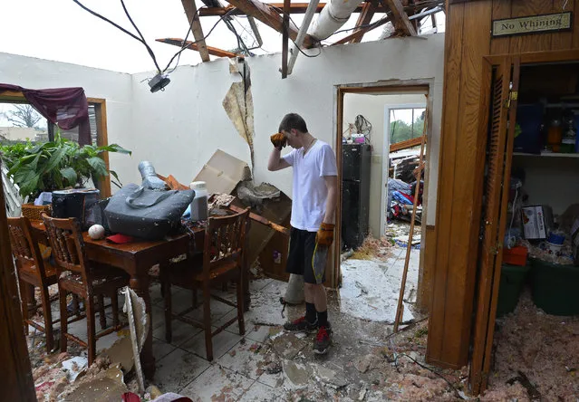 Shelby Van Sickle pauses while trying to salvage personal items in the family home that was destroyed after a tornado touched down overnight in Van, Texas, USA, 11 May 2015. Multiple storms moved across the state of Texas over the weekend causing flash flooding and tornados. (Photo by Larry W. Smith/EPA)