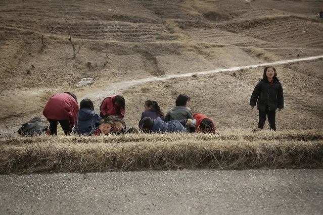 North Korean children rest at the side of a road on Monday, February 22, 2016, in Kaesong, North Korea. In response to the North's recent long-range rocket launch, Seoul shut down a factory park in Kaesong jointly run by both Koreas and this has cost the impoverished North a rare source of legitimate hard currency. (Photo by Wong Maye-E/AP Photo)