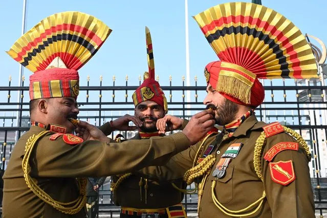 Indian Border Security Force (BSF) soldiers pose while offering sweets to each other during the celebrations to mark country's Republic Day at the India-Pakistan Wagah border post, about 35km from Amritsar on January 26, 2023. (Photo by Narinder Nanu/AFP Photo)