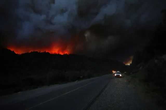 View of a huge fire behind the Route 40 in Paraje Villegas, Rio Negro province, 70 km south of Bariloche, Argentina, on December 29, 2021. Several sources of fire have been active for weeks in the Argentine provinces of Neuquen, Rio Negro and Chubut (south), where the flames have consumed thousands of hectares of native forest, amid adverse weather conditions, according to the authorities. (Photo by Francisco Ramos Mejia/AFP Photo)