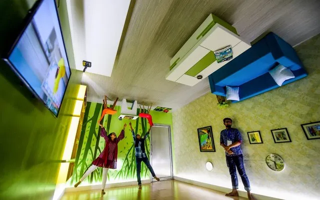 Visitors pose for a picture inside an upside-down cafeteria in Dhaka, Bangladesh on June 18, 2019. (Photo by Munir Uz Zaman/AFP Photo)