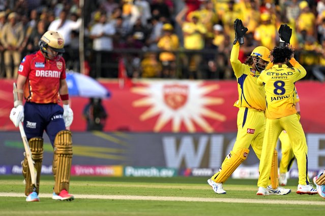 Chennai Super Kings' MS Dhoni, center, and teammate' Ravindra Jadeja celebrate the wicket of Punjab Kings' captain Sam Curran, left, during the Indian Premier League cricket match between Chennai Super Kings and Punjab Kings in Dharamshala, India, Sunday, May 5, 2024. (Photo by Ashwini Bhatia/AP Photo)