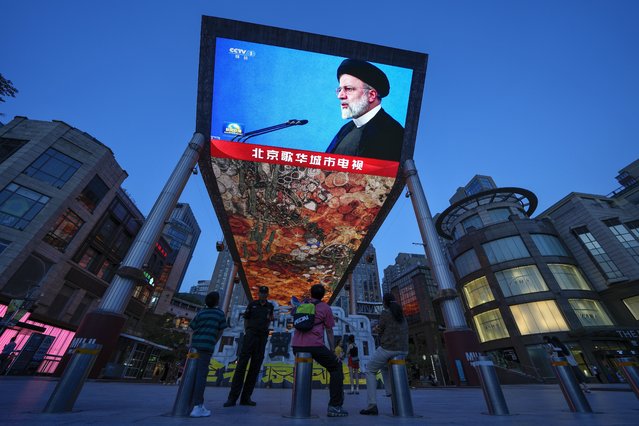 Residents watch a large screen showing a footage of Iranian President Ebrahim Raisi, during the evening news broadcast on his death, at an outdoor shopping mall in Beijing, Monday, May 20, 2024. Chinese President Xi Jinping expressed deep condolences on Monday over the death of Iranian President Ebrahim Raisi, according to the Foreign Ministry. (Photo by Andy Wong/AP Photo)