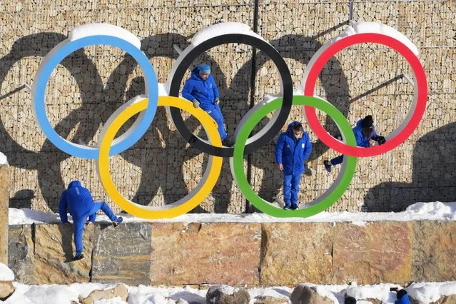 Ukraine team members climb on the Olympic Rings to pose for photo in the Olympic Village at the 2022 Winter Olympics, Monday, February 14, 2022, in the Yanqing district of Beijing. (Photo by Dmitri Lovetsky/AP Photo)
