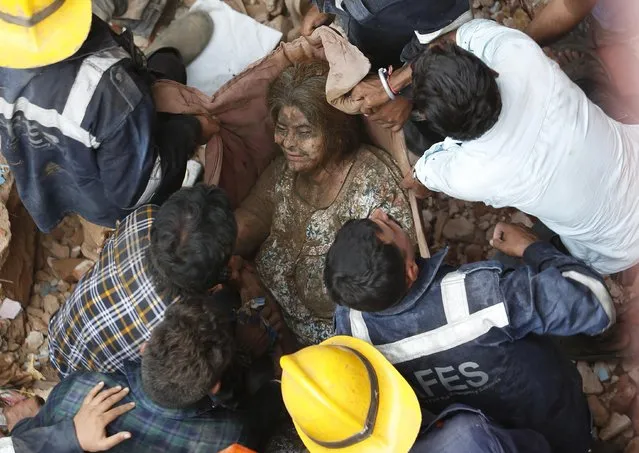 Rescuers carry a survivor at the site of a collapsed residential building in Ahmedabad, India, September 5, 2019. (Photo by Amit Dave/Reuters)