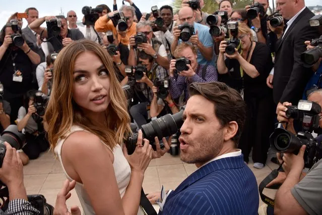 Ana de Armas  uses a photographer's camera as Edgar Ramirez looks on during the “Hands Of Stone” photocall during the 69th annual Cannes Film Festival at the Palais des Festivals on May 16, 2016 in Cannes, France. (Photo by Clemens Bilan/Getty Images)