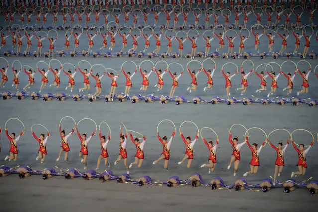 A photo taken on June 4, 2019 shows performers during a “Grand Mass Gymnastics and Artistic Performance”, or mass games, at the May Day stadium in Pyongyang. The “Grand Mass Gymnastics and Artistic Performance” features enormous numbers of people – mostly students and children – performing synchronised moves. Tens of thousands of performers in Pyongyang took part in the first of North Korea's spectacular “Mass Games” propaganda displays for 2019, but the show left leader Kim Jong Un unimpressed. (Photo by Kim Won Jin/AFP Photo)