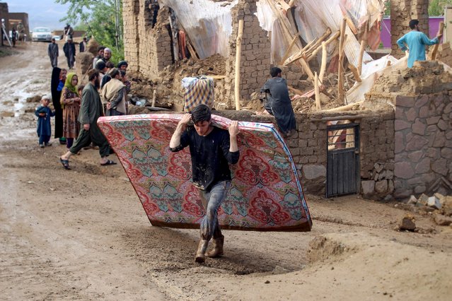 Afghan residents clean debris and salvage their belongings after flash floods following heavy rainfall at a damaged house in Firozkoh, Ghor province on May 18, 2024. Flash flooding has killed at least 50 people in western Afghanistan, provincial police said on May 18, a week after hundreds were washed away in the north of the country. (Photo by AFP Photo/Stringer)