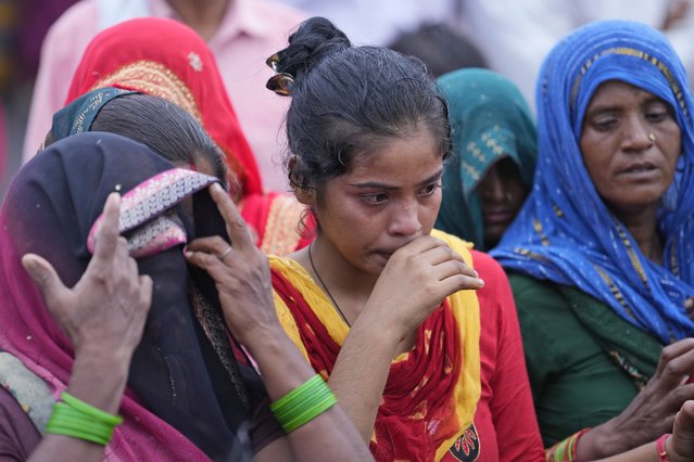 Villagers watch as family members prepare for the last rites of Savitri Devi, 50, who died during a stampede, in Ramnagar, in the northern Indian state of Uttar Pradesh, Wednesday, July 3, 2024. (Photo by Rajesh Kumar Singh/AP Photo)