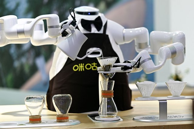 A robot makes coffee during the World Intelligence Expo in Tianjin on June 23, 2024. (Photo by Pedro Pardo/AFP Photo)