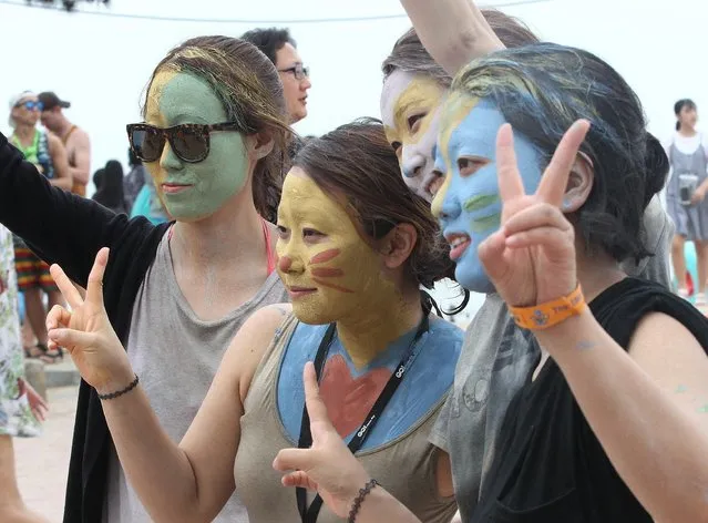Women wear colored mud on their faces during the Boryeong Mud Festival at Daecheon Beach in Boryeong, South Korea, Saturday, July 18, 2015. The 18th annual mud festival features mud wrestling and mud sliding.(Photo by Ahn Young-joon/AP Photo)