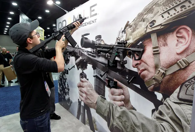 Sam Love looks over guns from Daniel Defense at the National Rifle Association's annual meetings and exhibits show in Louisville, Kentucky, May 21, 2016. (Photo by John Sommers II/Reuters)