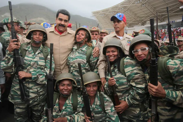 Venezuela's President Nicolas Maduro (back row 2nd L) poses for a photo with militia members during a military parade in La Guaira, Venezuela May 21, 2016. (Photo by Miraflores Palace/Reuters)
