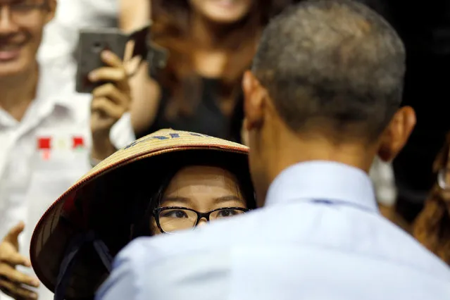 A woman wearing a traditional vietnamese hat talks with U.S. President Barack Obama during a town hall meeting with members of the Young Southeast Asian Leaders Initiative (YSEALI) at the GEM Center in Ho Chi Minh City, Vietnam May 25, 2016. (Photo by Carlos Barria/Reuters)