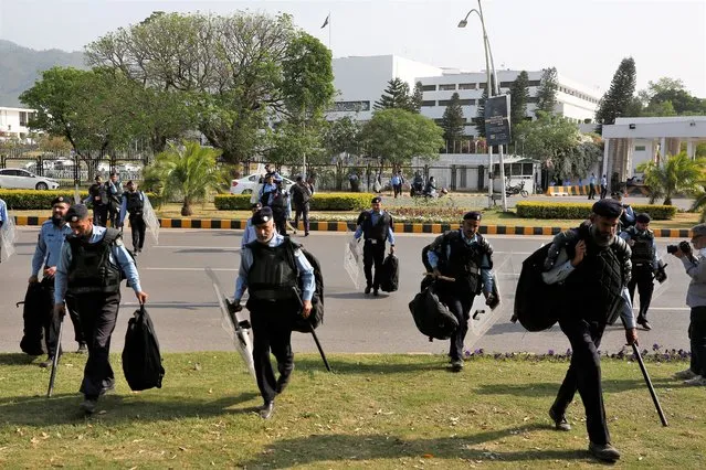 Police officers with riot gears arrive to take position outside the National Assembly, in Islamabad, Pakistan, Saturday, April 9, 2022. Pakistan's embattled prime minister faces a tough no-confidence vote Saturday waged by his political opposition, which says it has the numbers to defeat him. (Photo by Anjum Naveed/AP Photo)