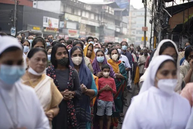 Indian Christians wearing masks as a precaution against COVID-19 gather for prayers as they observe Palm Sunday in Kochi, Kerala state, India, Sunday, April 10, 2022. The South Asian country has recorded a steep dip in coronavirus cases in recent weeks, with the health ministry reporting approximately 1,100 cases on Friday. (Photo by R.S. Iyer/AP Photo)