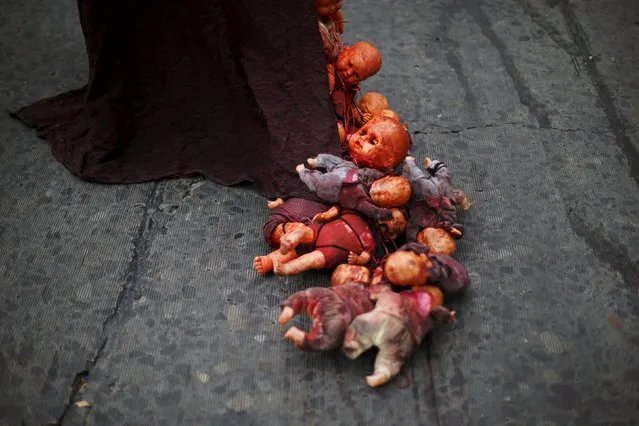 A demonstrator drags dolls painted in red during a rally held to support women's rights to an abortion in Santiago, Chile, July 25, 2015. (Photo by Ivan Alvarado/Reuters)