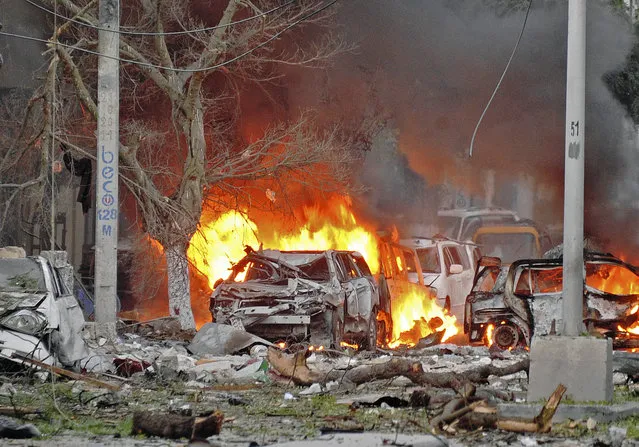Wrecked cars burn at the scene of a terror attack at the Ambassador Hotel, after a car bomb exploded on June 1, 2016 at a top Mogadishu hotel that houses several MPs, killing several people, and followed by a gun battle. Somalia's Al-Qaeda-linked al-Shabaab group was chased out of the capital Mogadishu in 2011 but remains a dangerous threat in both Somalia and neighbouring Kenya, where it carries out frequent attacks. (Photo by Mohamed Abdiwahab/AFP Photo)