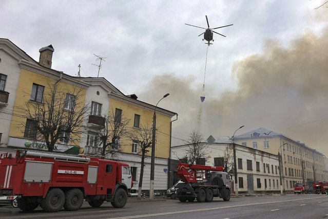 A helicopter dumps water onto the burning building of the Central Research Institute of the Aerospace Defense Forces in the Russian city of Tver, Russia, Thursday, April 21, 2022. (Photo by Vitaliy Smolnikov/Kommersant Publishing House via AP Photo)
