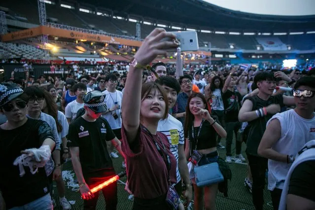 South Korean youths take selfies while they dance to electronic music during the Ultra Music Festival Korea at Olympic Stadium on June 10, 2016 in Seoul, South Korea. (Photo by Jean Chung/Getty Images)