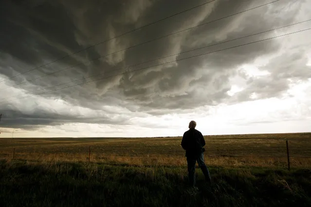 Tim Marshall, a 40 year veteran of storm chasing, monitors a supercell thunderstorm during a tornado research mission, May 8, 2017 in Elbert County near Agate, Colorado. With funding from the National Science Foundation and other government grants, scientists and meteorologists from the Center for Severe Weather Research try to get close to supercell storms and tornadoes trying to better understand tornado structure and strength, how low-level winds affect and damage buildings, and to learn more about tornado formation and prediction. (Photo by Drew Angerer/Getty Images)