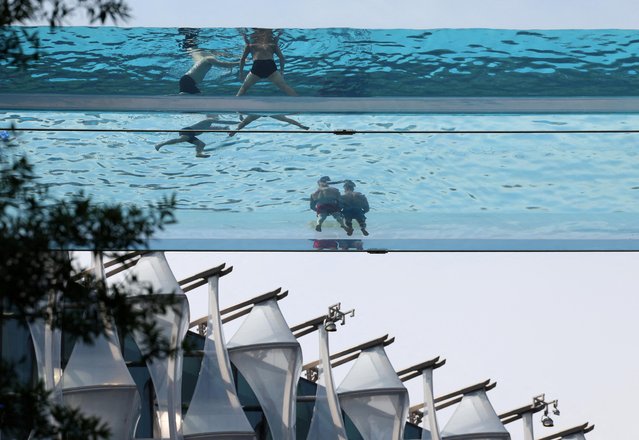 People relax in a swimming pool suspended between two buildings as hot weather continues, in London, Britain on June 12, 2023. (Photo by Toby Melville/Reuters)