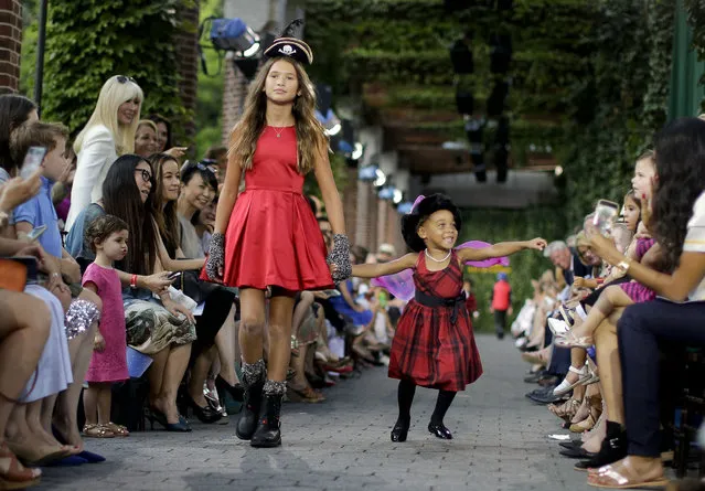 Child models walk the runway wearing Ralph Lauren children's Fall fashion, Wednesday, August 5, 2015, at the Central Park Zoo in New York. Polo hosted the show to promote children's literacy but also to promote the October film, “Pan”, which is Peter Pan's origin story. (Photo by Julie Jacobson/AP Photo)