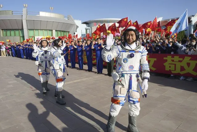 In this photo released by Xinhua News Agency, Chinese astronaut Chen Dong, right, waves as he walks ahead of fellow astronauts Liu Yang and Cai Xuzhe during a sendoff ceremony for the Shenzhou-14 crewed space mission at the Jiuquan Satellite Launch Center in northwestern China on Sunday, June 5, 2022. China on Sunday launched the new three-person mission to complete work on its permanent orbiting space station. (Photo by Li Gang/Xinhua via AP Photo)