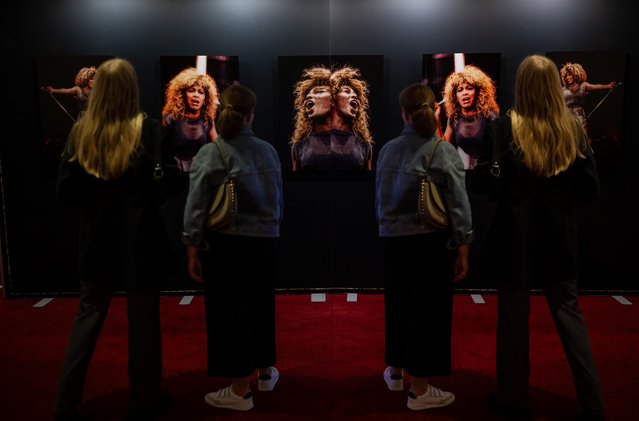 Visitors are captured in front of Tina Turner pictures during the opening of the Tina Turner Exhibition at Stage Apollo Theater on August 2, 2023 in Stuttgart, Germany. (Photo by Daniel Kopatsch/Getty Images)