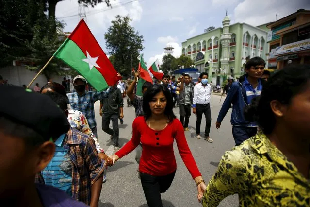 Protesters hold hands and march on a road during a general strike organised by a 30-party alliance led by a hardline faction of former Maoist rebels, who are protesting against the draft of the new constitution, in Kathmandu, Nepal August 16, 2015. (Photo by Navesh Chitrakar/Reuters)