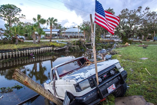 A truck hangs on the ledge of a channel full of debris after the Hurricane Idalia made landfall, in Horseshoe Beach, Florida, USA, 30 August 2023. Hurricane Idalia makes landfall in Florida as a Category 3 storm with winds of 125 mph. (Photo by Cristóbal Herrera/EPA/EFE)