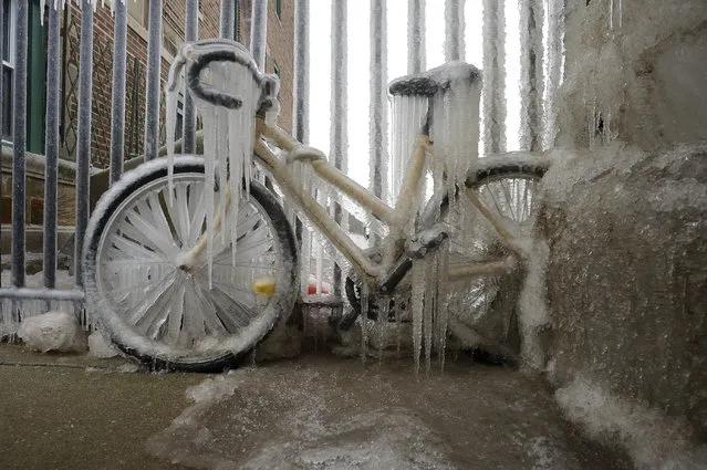 A bicycle is covered in a thick layer of ice near East 73th Street in Chicago, Thursday, February 13, 2020. (Photo by Victor Hilitski/Chicago Sun-Times via AP Photo)