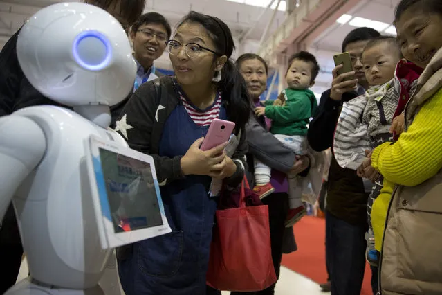 Pepper, a companion robot from e-commerce giant Alibaba, attracts visitors during the World Robot Conference in Beijing, China, Friday, October 21, 2016. (Photo by Ng Han Guan/AP Photo)