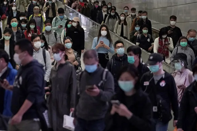 People wear face masks as a precaution against the COVID-19 illness as they walk inside a subway station during rush hour in Hong Kong, Wednesday, March 11, 2020a. (Photo by Kin Cheung/AP Photo)
