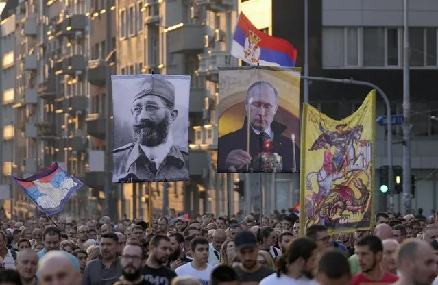 People display the images of Russian President Vladimir Putin, center, and controversial Serb World War II leader Gen. Dragoljub Draza Mihailovic, left, during a protest against the international LGBT event EuroPride in Belgrade, Serbia, Sunday, August 28, 2022. Members of the European Pride Organizers Association chose Serbia's capital three years ago to host the annual event. Serbia won't allow a pan-European LGBTQ Pride event to take place in Belgrade next month, Serbian President Aleksandar Vucic said Saturday, citing threats from right-wing extremists and fears of clashes. (Photo by Darko Vojinovic/AP Photo)