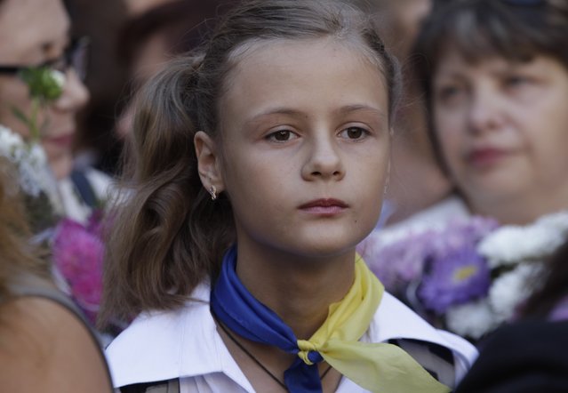 A schoolgirl attends morning assembly in a school in the southern coastal town of Mariupol, September 1, 2014.  September 1 marks the start of a new academic year for students in Ukraine. (Photo by Vasily Fedosenko/Reuters)