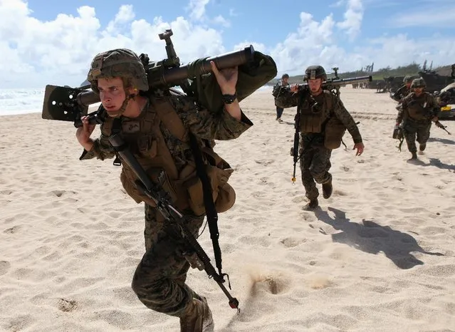 U.S. Marines run down the beach to set up a mortar defense during a simulated beach assault at Marine Corps Base Hawaii with the 3rd Marine Expeditionary Unit during the multi-national military exercise RIMPAC in Kaneohe, Hawaii, July 30, 2016. (Photo by Hugh Gentry/Reuters)