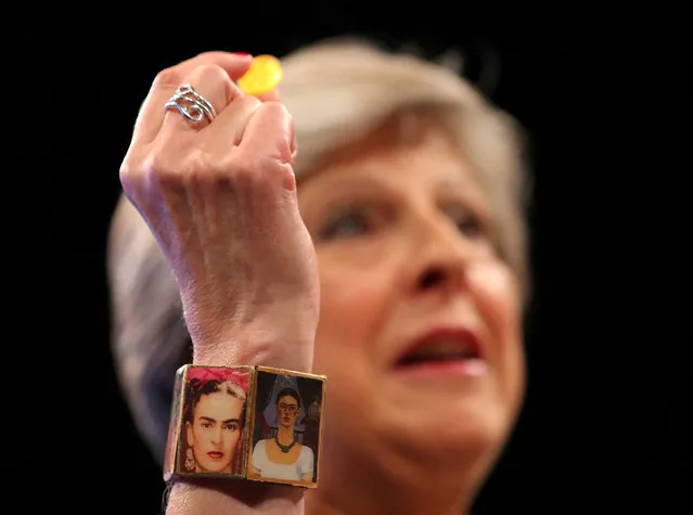 Britain's Prime Minister Theresa May wears a 'Frida Kahlo' bracelet and holds a sweet passed to her as she addresses the Conservative Party conference in Manchester, October 4, 2017. (Photo by Hannah McKay/Reuters)