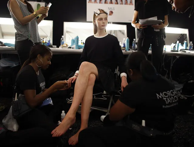 Fashion model Dasha Jold, 18, of Yekaterinburg, Russia, has her nails done backstage before the Monique Lhuillier Spring 2015 collection show Friday, September 5, 2014, during Fashion Week in New York. Jold was scouted on the street in her native Russia, at age 17. She struggles sometimes with homesickness, but says that keeping in touch through services like Skype helps ease those feelings. (Photo by Jason DeCrow/AP Photo)