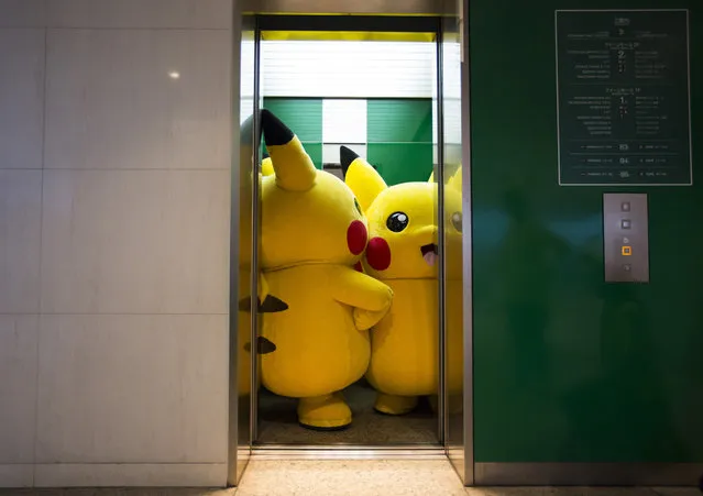 Performers dressed as Pikachu, a character from Pokemon series game titles, ride on an elevator during the Pikachu Outbreak event hosted by The Pokemon Co. on August 7, 2016 in Yokohama, Japan. (Photo by Tomohiro Ohsumi/Getty Images)