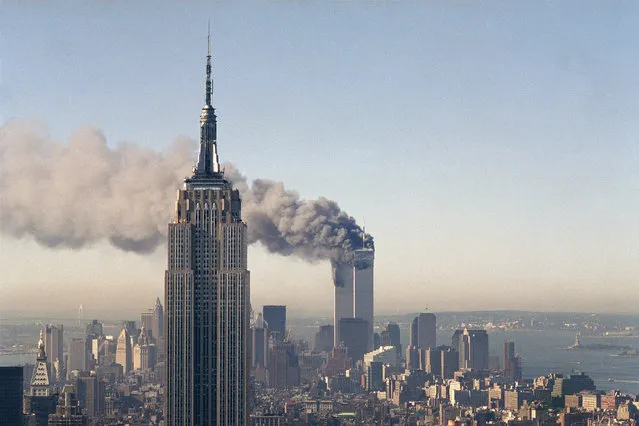 In this September 11, 2001, file photo, the twin towers of the World Trade Center burn behind the Empire State Building in New York. The Sept. 11, 2001 terrorist attack is by far the most memorable moment shared by television viewers during the past 50 years, a study released on Wednesday, July 11, 2012, concluded. (Photo by Marty Lederhandler/AP Photo)