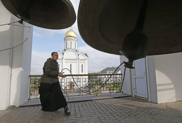 Russian Orthodox priest rings the bell  during a religious procession devoted to  the memory of Grand Dushess Yelizaveta Fiodorovna near her residence in Usovo, Moscow region, September 13, 2015. German born Saint Grand Dushess Yelizaveta Fiodorovna was a sister of a wife of Russian Tzar Nicholas II and a wife of Moscow General- Governor Sergiy, an uncle of Nicholas II. (Photo by Sergei Chirikov/EPA)