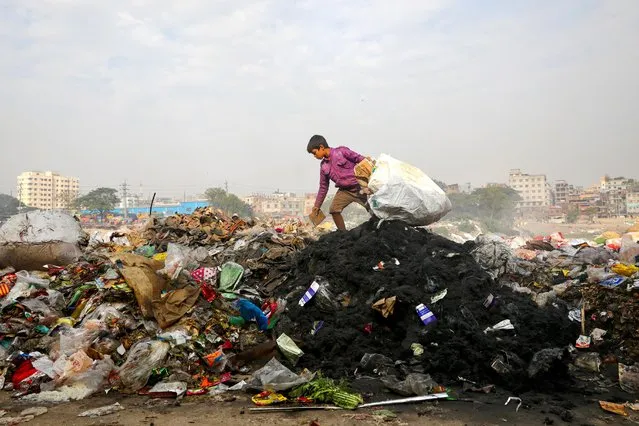 A boy collects materials from waste dumped in the bank of Buriganga River in Dhaka, Bangladesh on January 2, 2020. (Photo by Mohammad Ponir Hossain/Reuters)